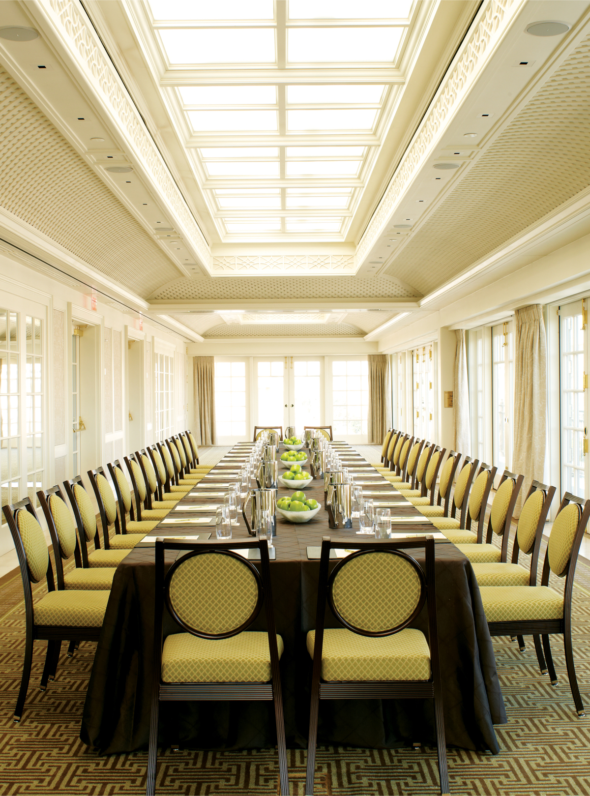 A large, bright meeting room with a long table and multiple chairs