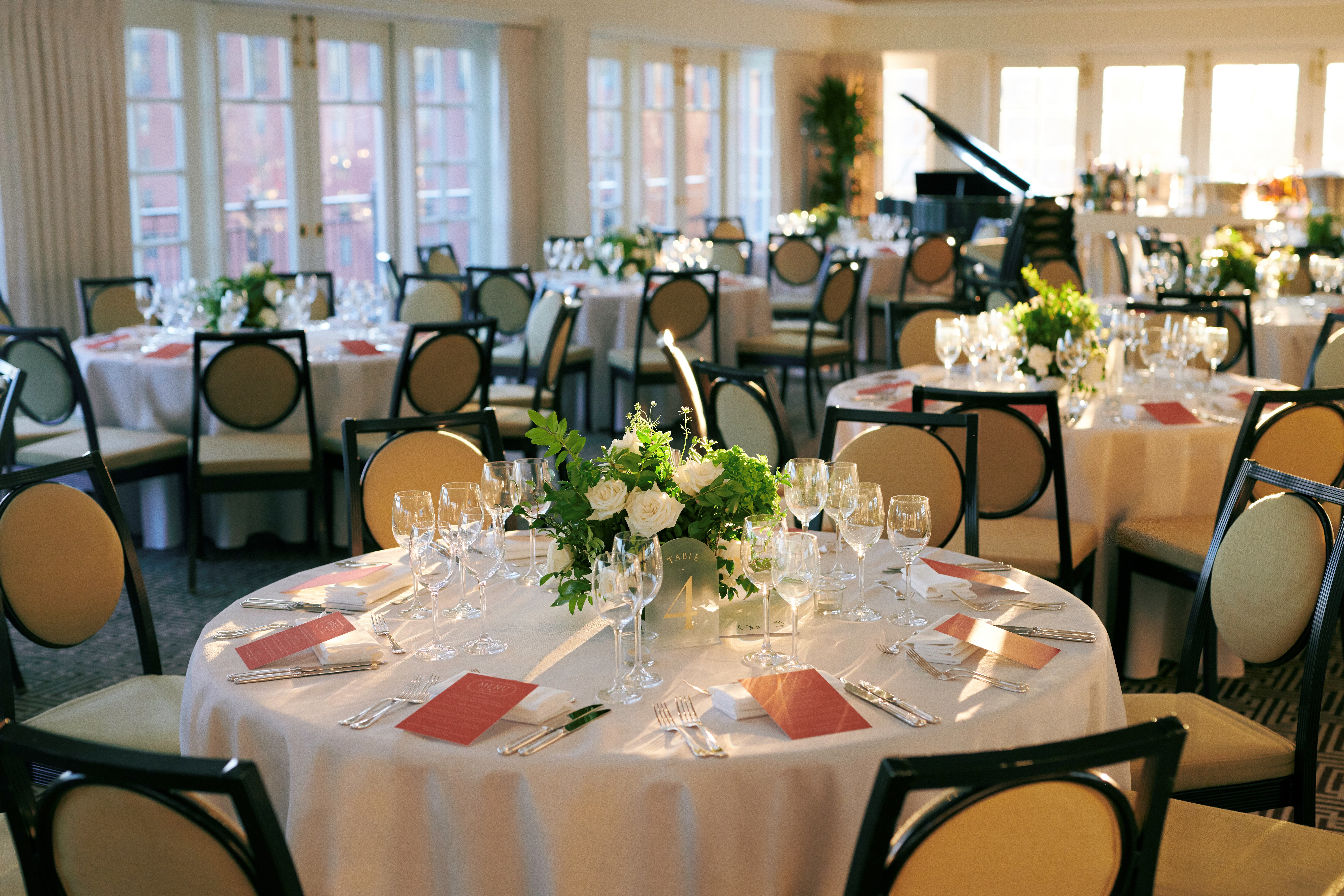 a formal dining room with round tables set for a meal