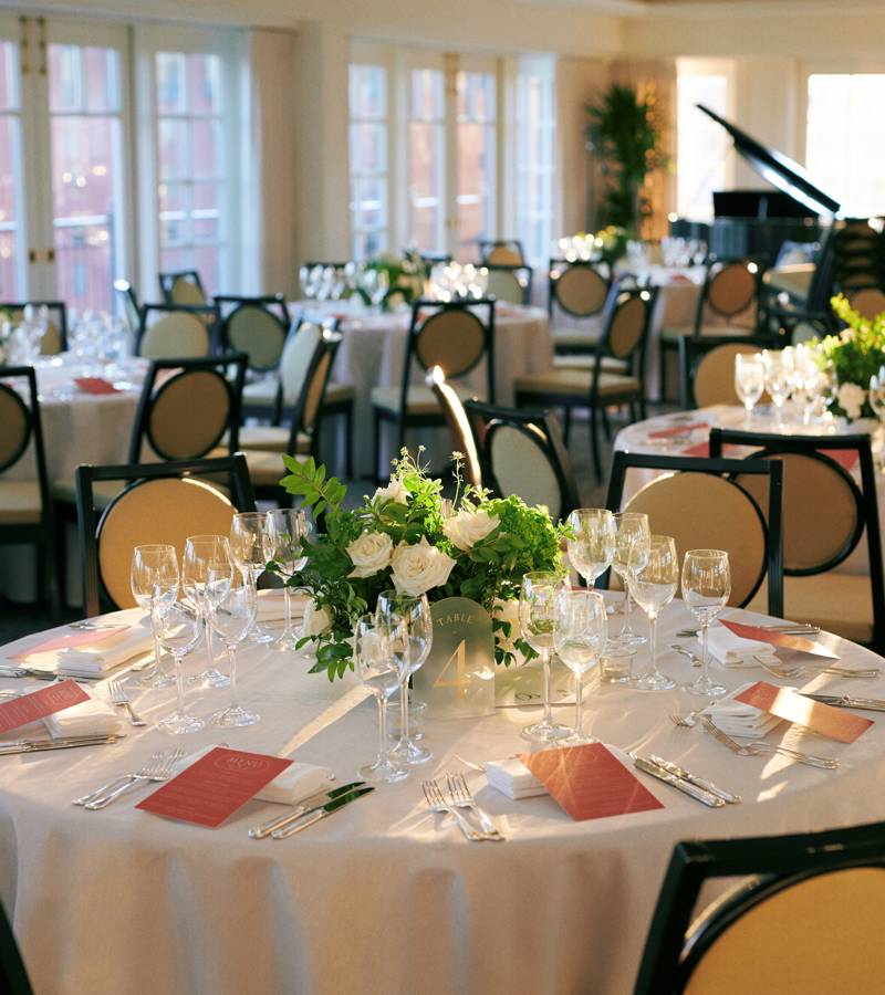 a formal dining room with round tables set for a meal