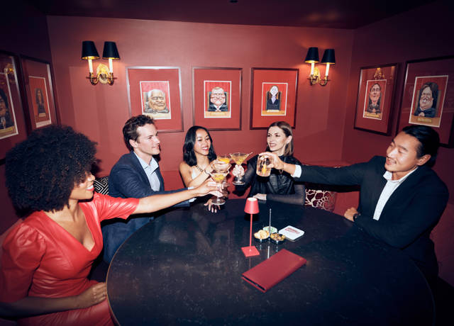 A group enjoying drinks at The Hay Adams, surrounded by ambient lighting and modern artwork.