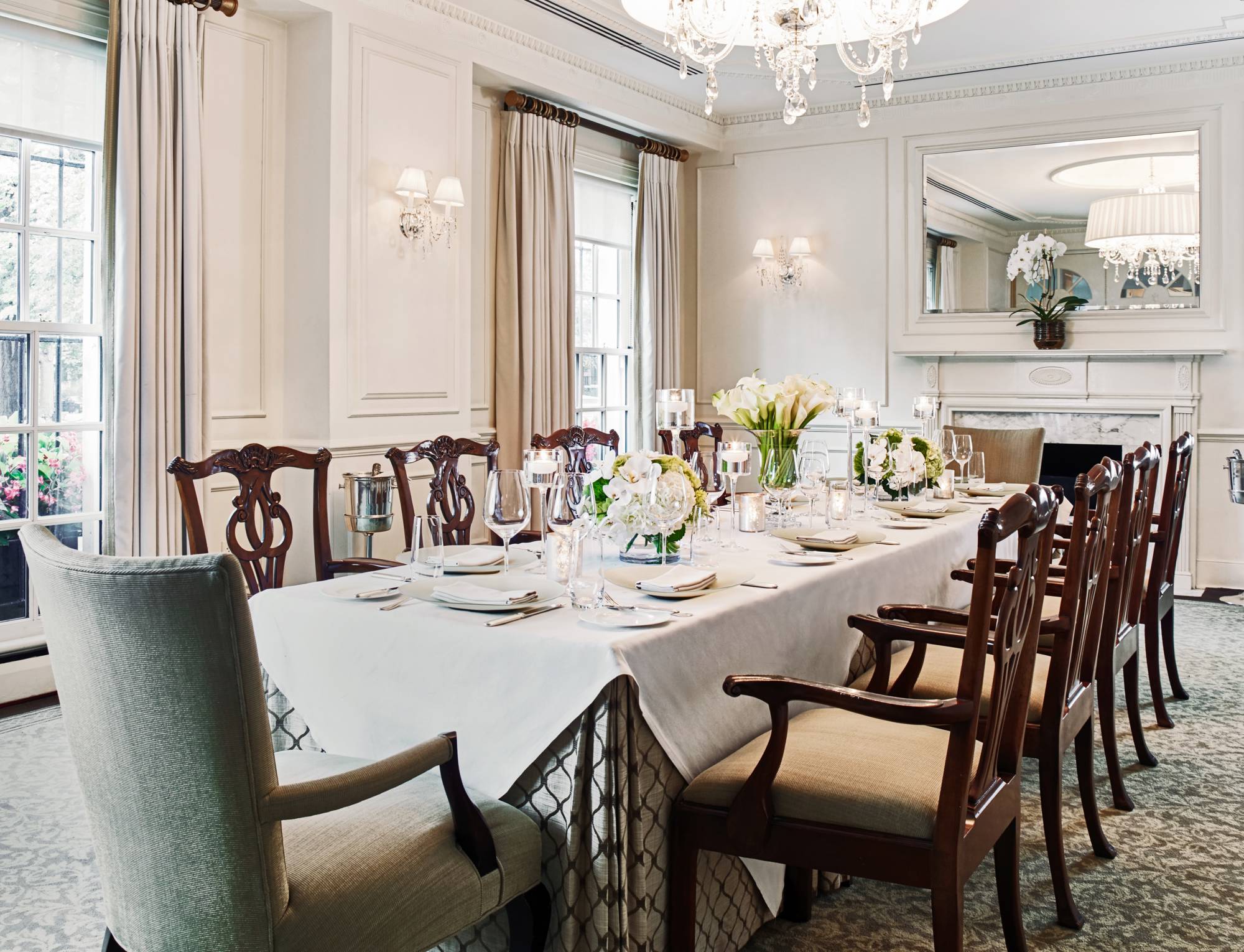 A formal dining room with a large table set for a meal.