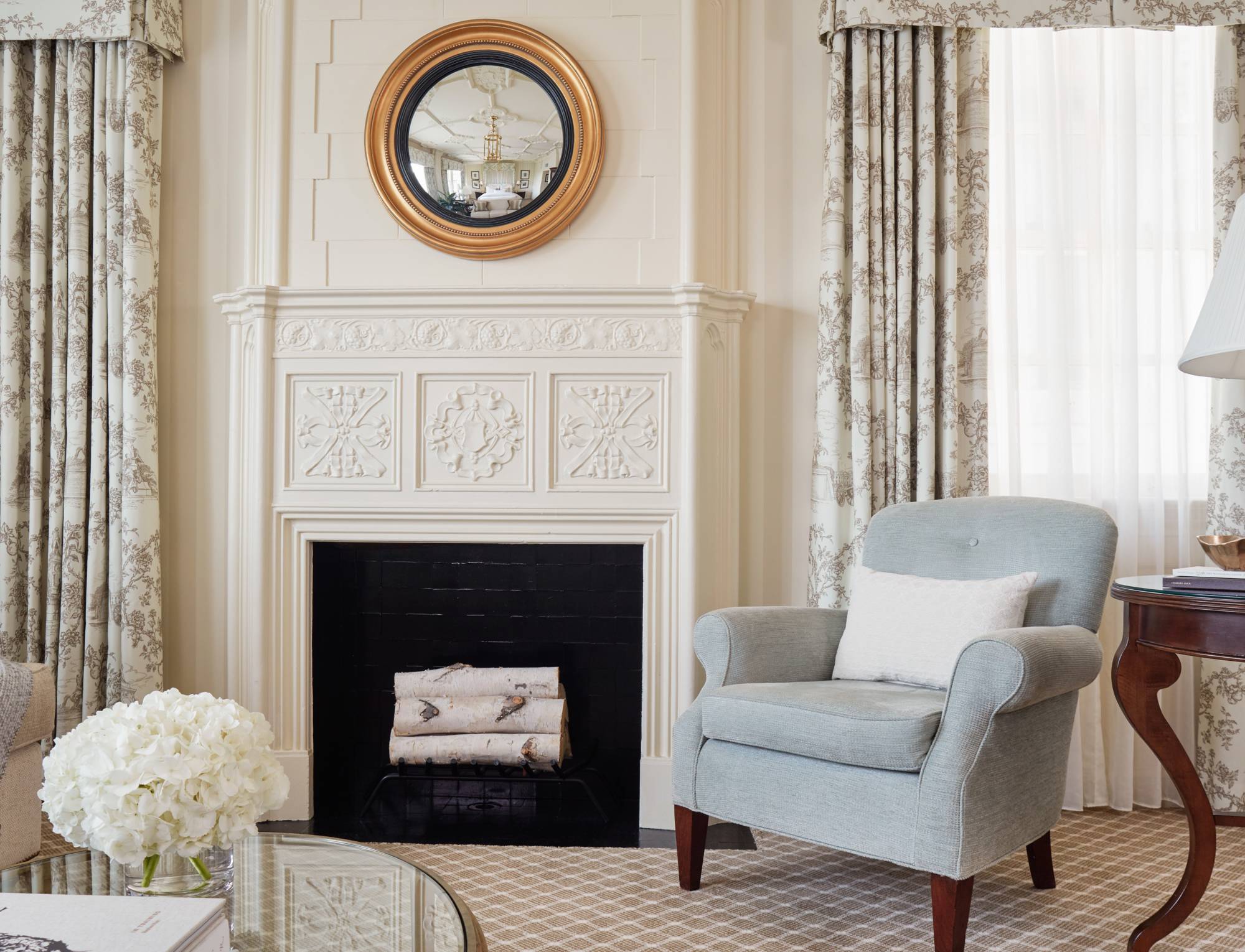 A luxurious lounge with a fireplace, armchair, and coffee table.